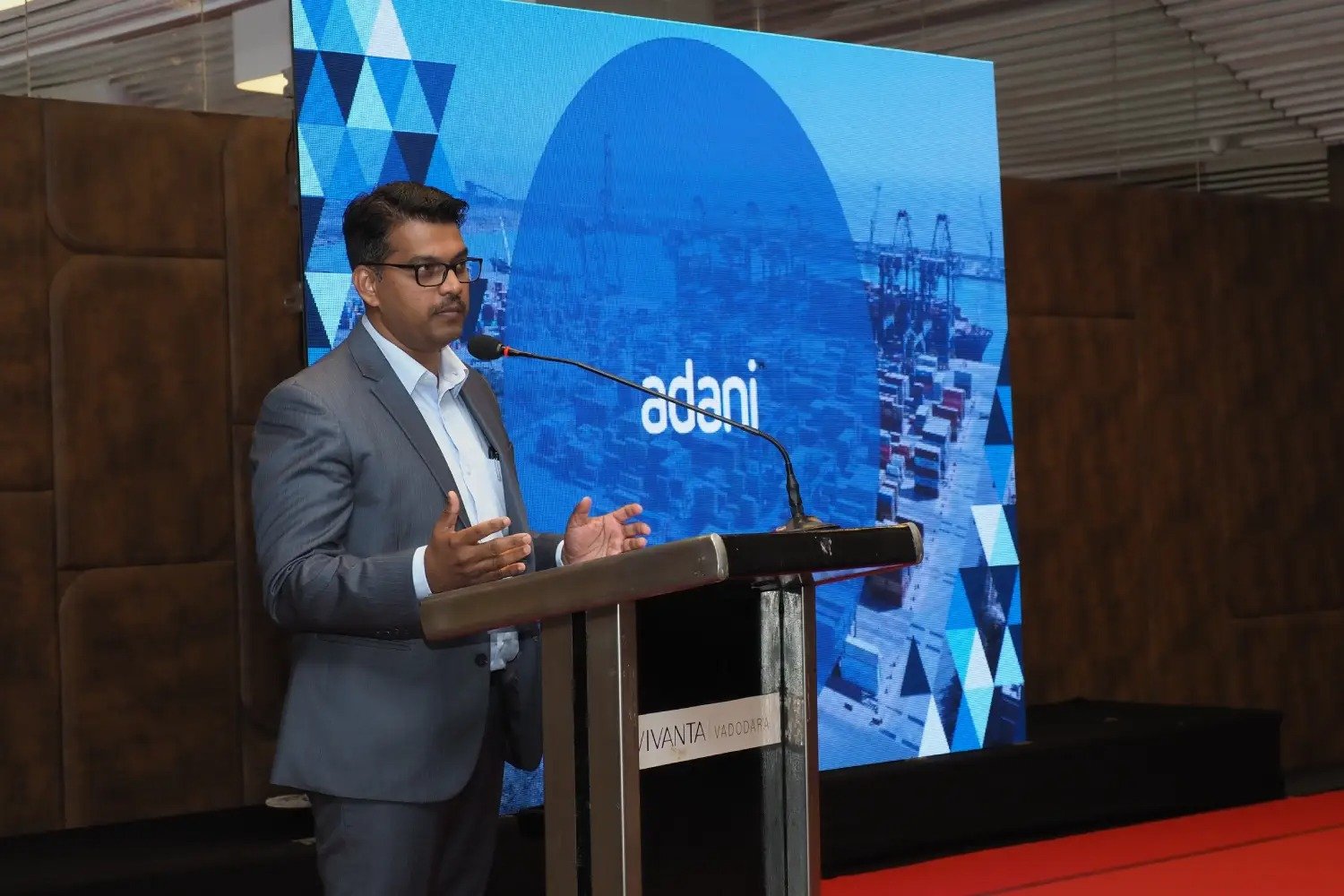 Balloon arch in orange, black, and white colors framing an ITT logo board lit with warm lights