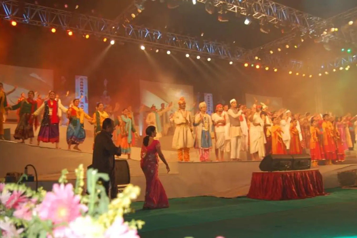 Festival Celebrations with people dancing on stage and colorful lighting