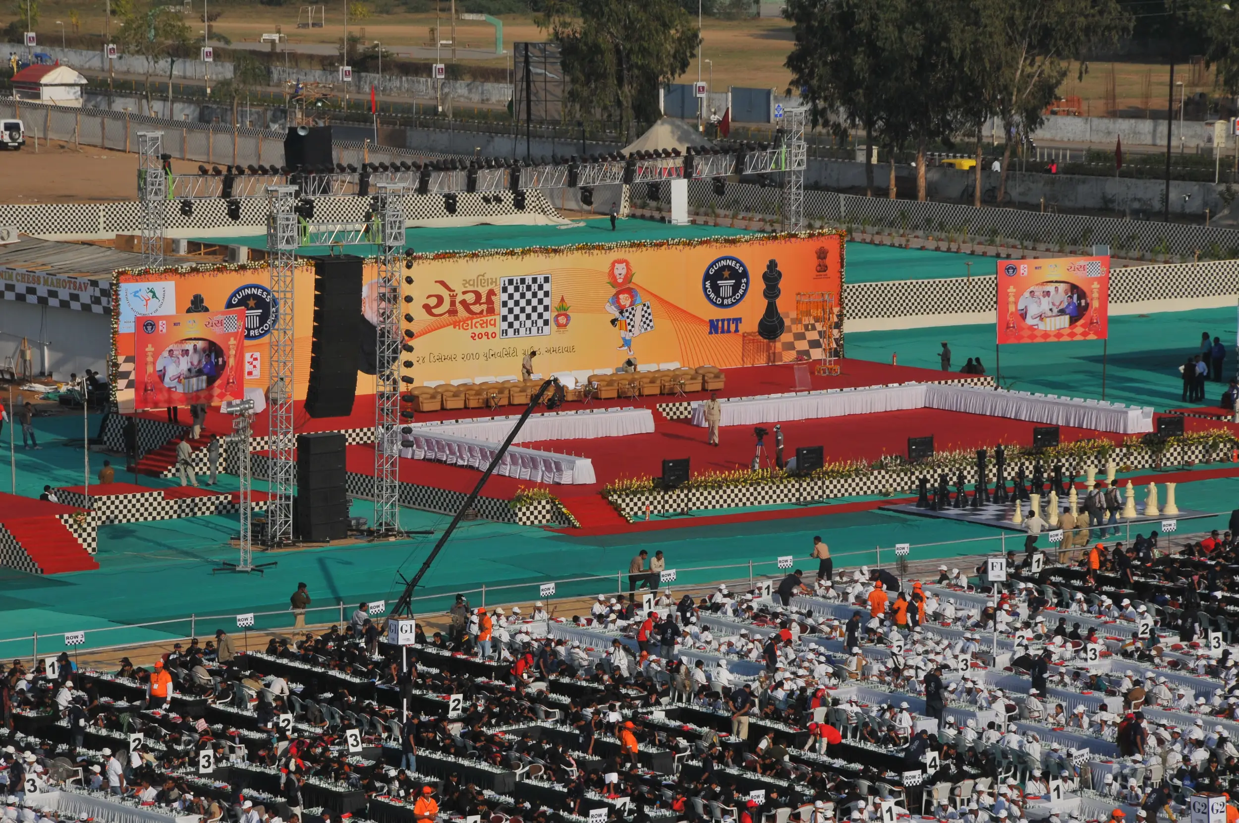 Men lighting ceremonial lamp at event with ITT banner in background