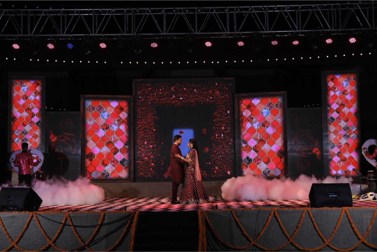Balloon arch in orange, black, and white colors framing an ITT logo board lit with warm lights