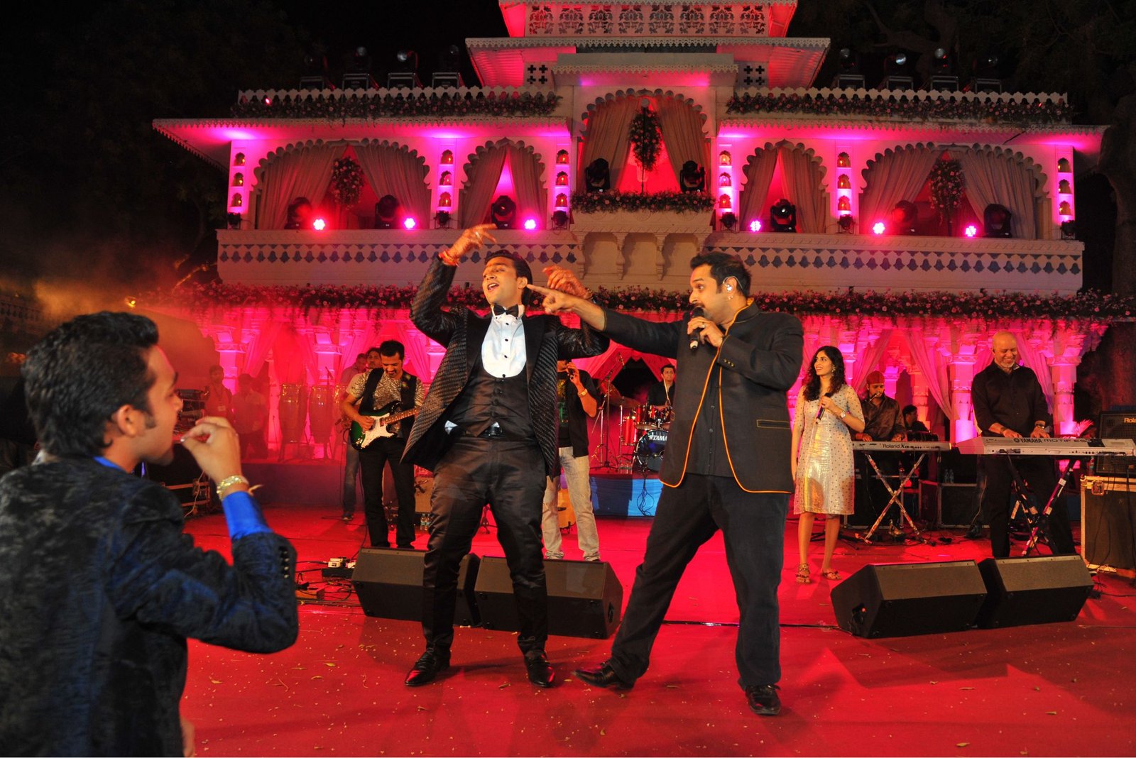Men lighting ceremonial lamp at event with ITT banner in background