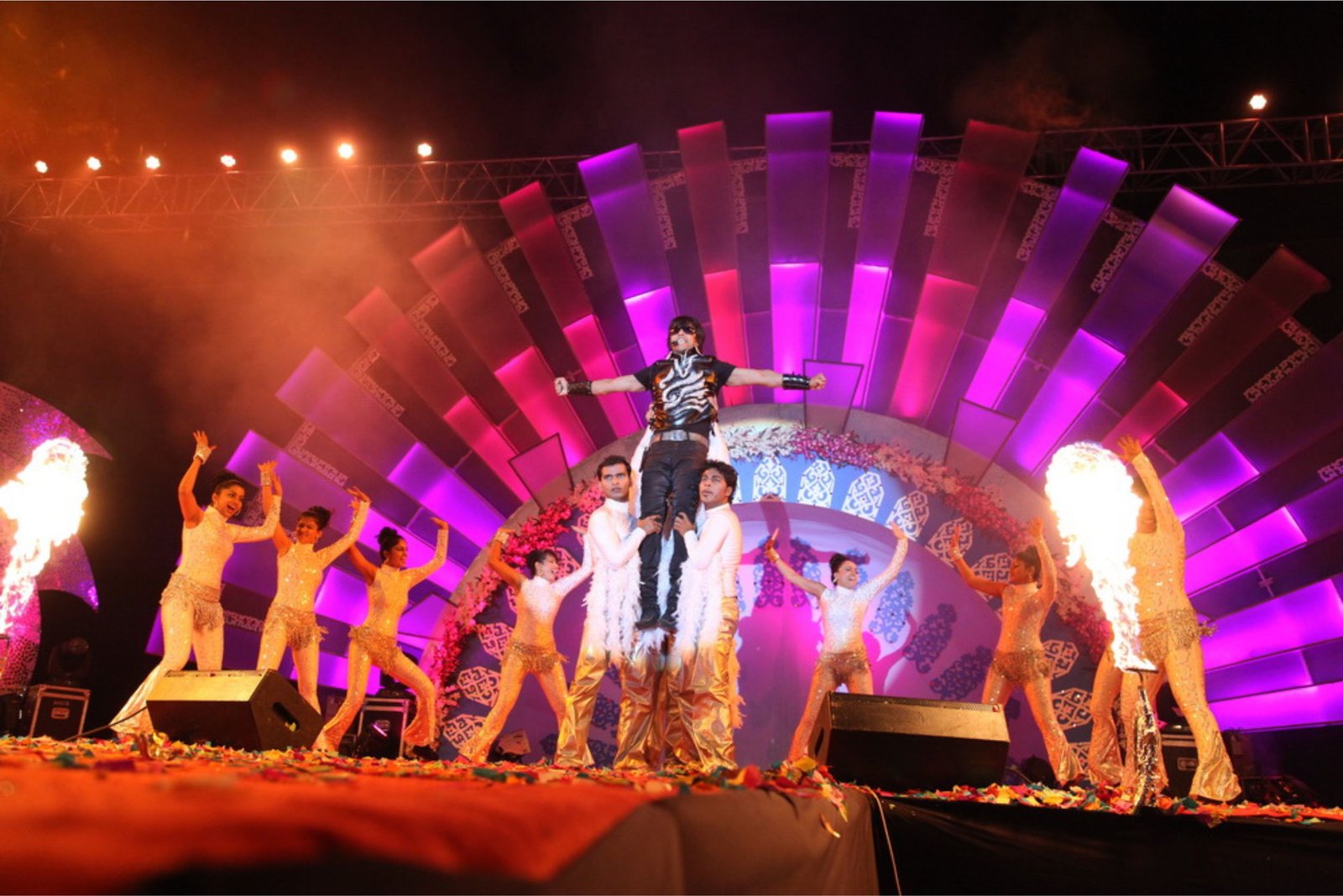 Men lighting ceremonial lamp at event with ITT banner in background
